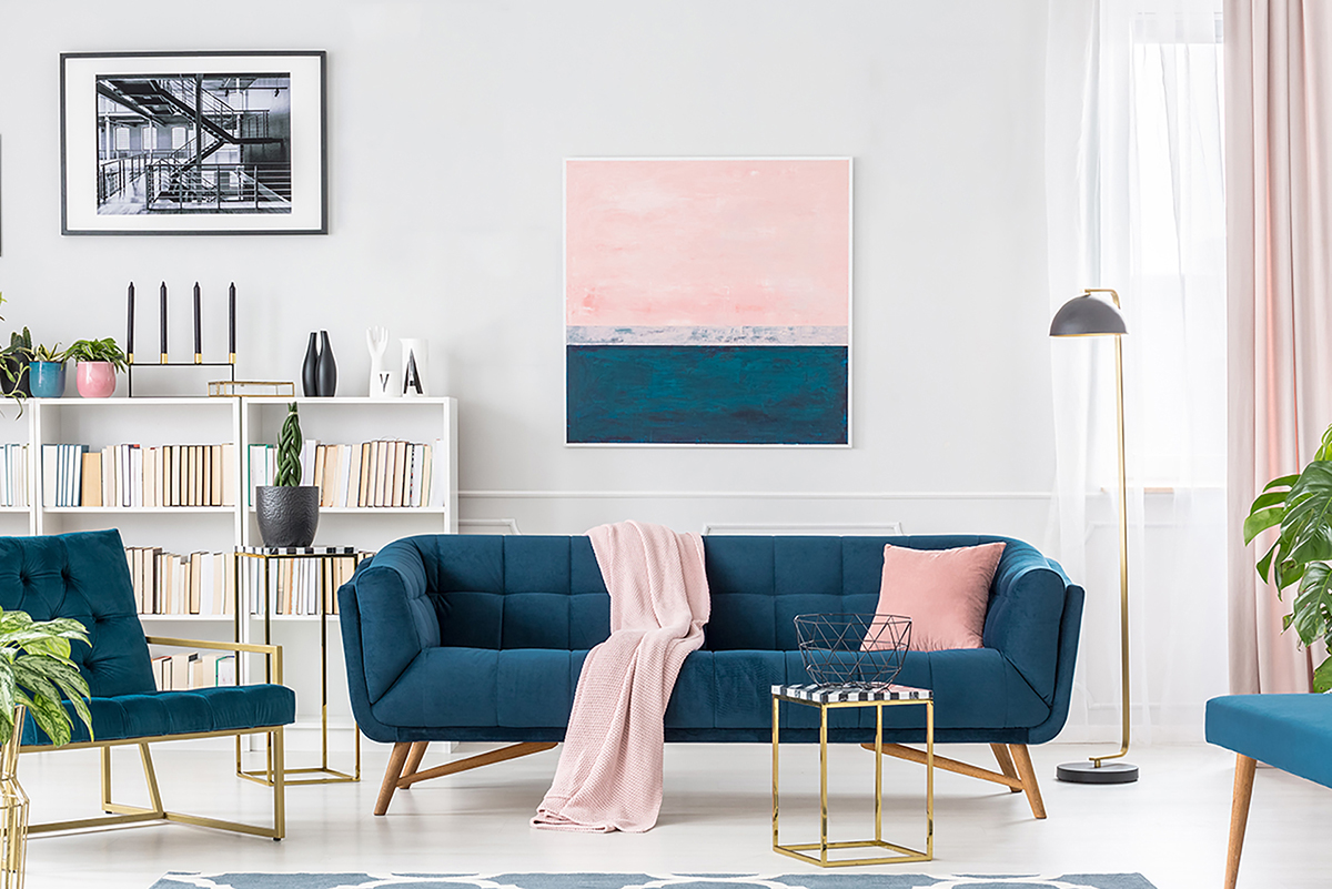 Soggiorno luminoso ed elegante con arredi blu rosa e oro